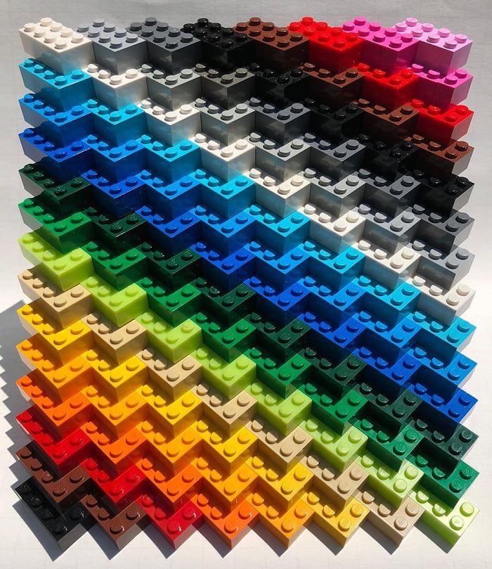 many different colored legos are arranged in the shape of a rainbow and black triangle