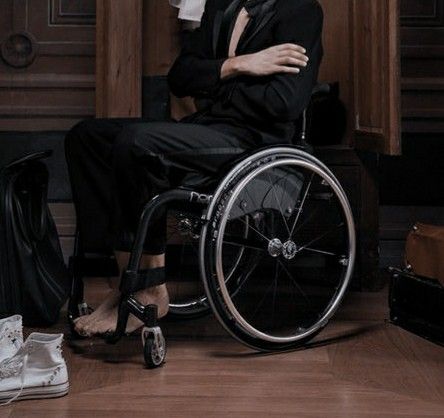 a man in a suit and tie sitting in a wheelchair