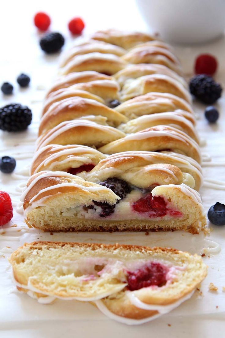 a long loaf of bread with berries and raspberries on it