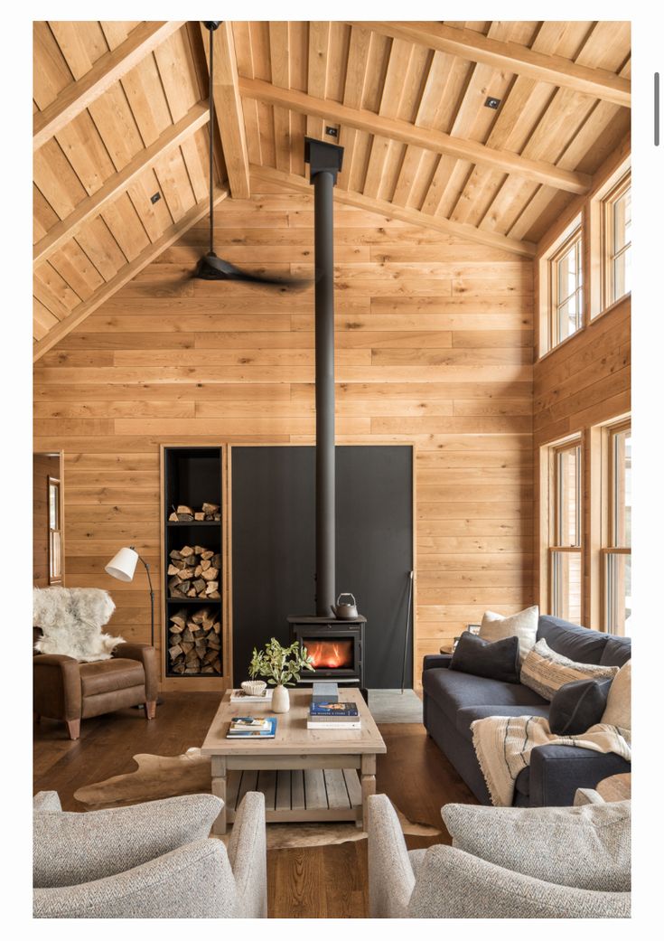 a living room filled with furniture and a wood burning stove in the middle of it