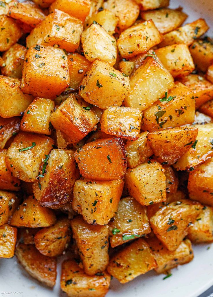 a white plate topped with cooked potatoes covered in seasoning