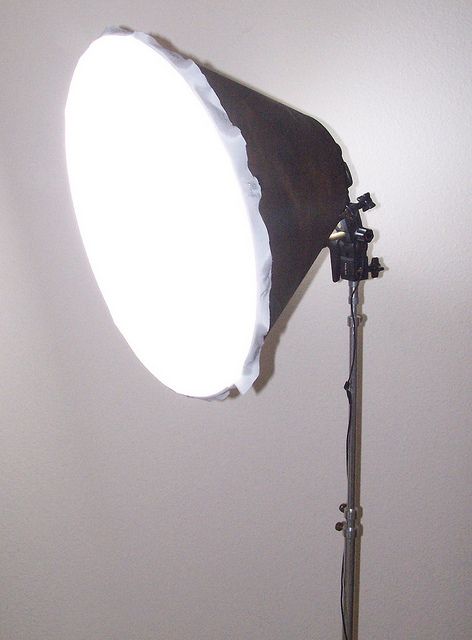 a light that is on top of a tripod in the corner of a room