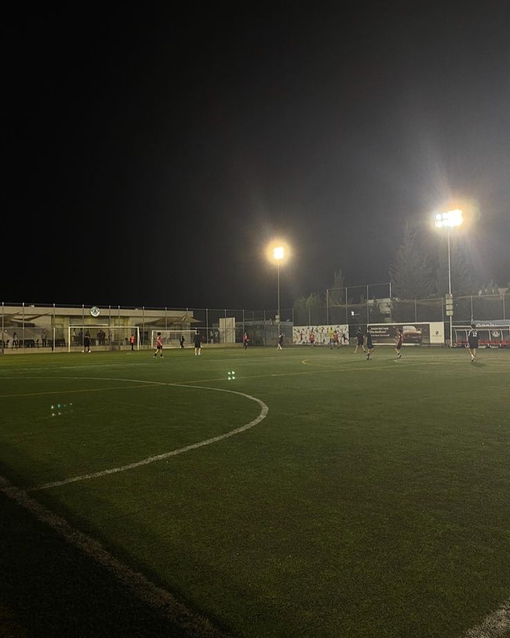 a soccer field at night with the lights on