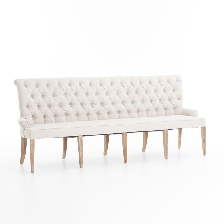 a white couch sitting on top of a wooden bench