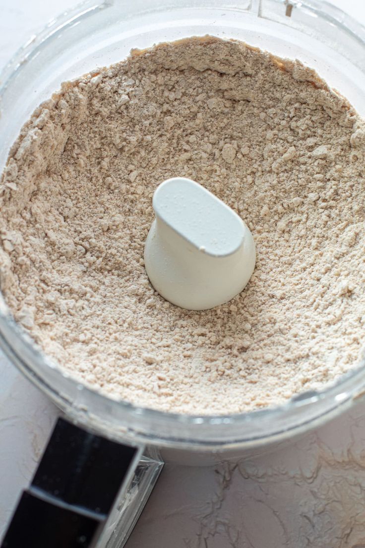 a food processor filled with dry ingredients on top of a counter