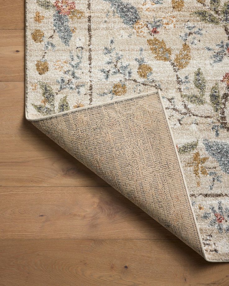 an area rug on the floor with wooden floors and wood planks in the background