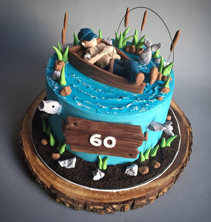 a blue cake with an image of a man in a boat on the lake and fish