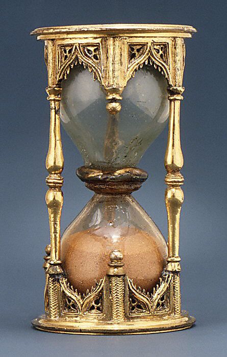 an old fashioned sand timer with two eggs in it's display case on a blue background