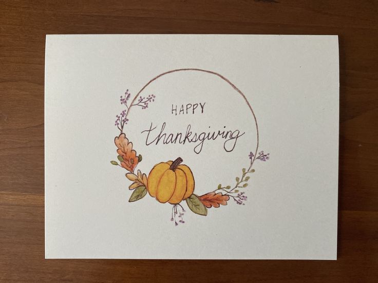 a thanksgiving card with an orange pumpkin and floral wreath on the front that says happy thanksgiving