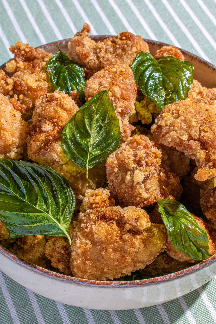 a close up of a bowl of food with leaves on the top and in the middle