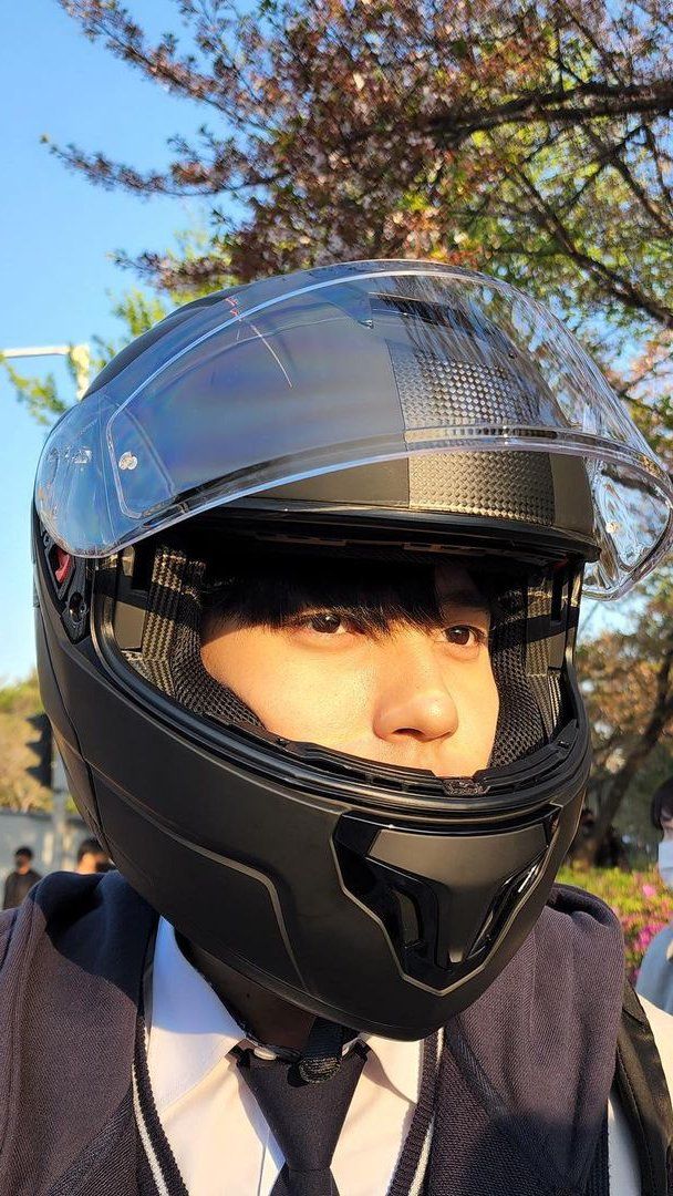 a man wearing a black helmet and tie