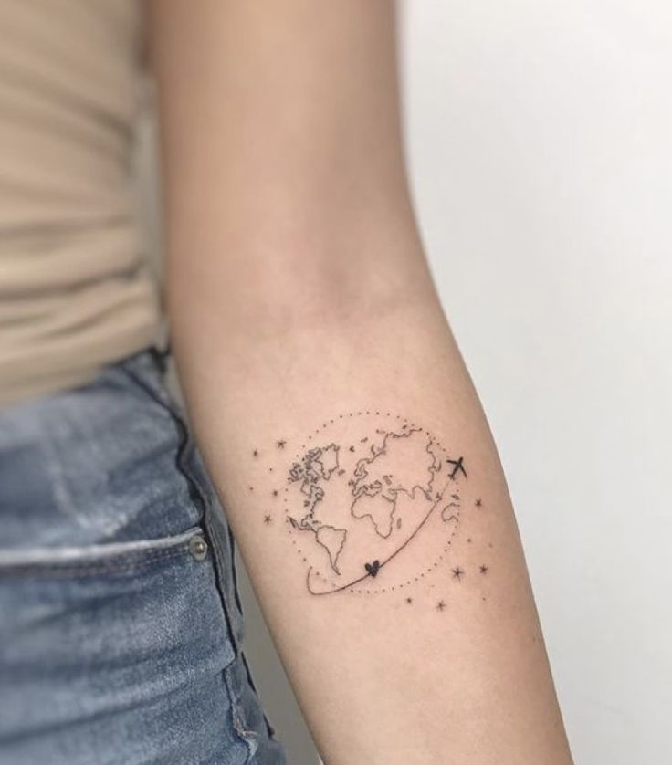 a woman's arm with a small world map tattoo on the left inner arm