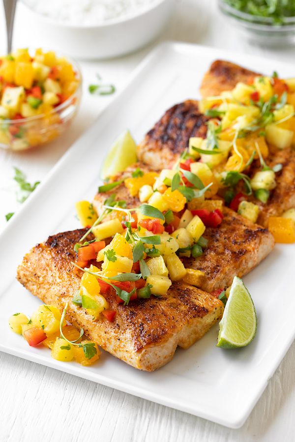 a white plate topped with fish covered in veggies