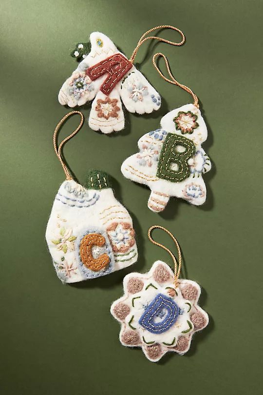 three ornaments are hanging on a green surface