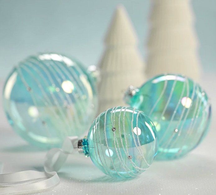 three glass ornaments sitting next to each other on a table