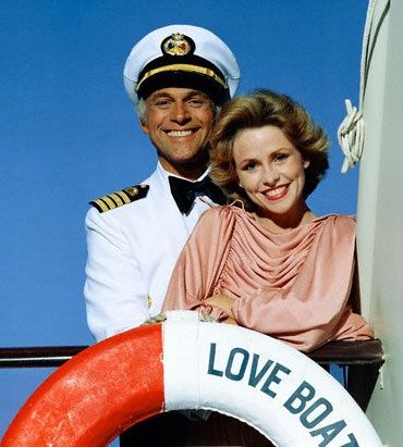 a man and woman in sailor's uniforms standing on the deck of a boat