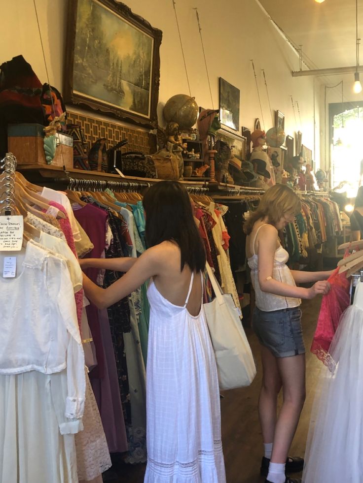 two women looking at dresses in a clothing store