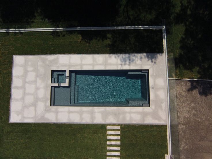 an aerial view of a pool in the middle of a yard