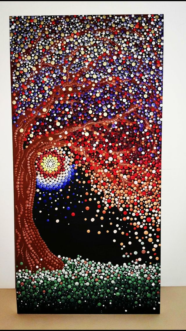 the painting is made up of many different colored dots and has a tree on it