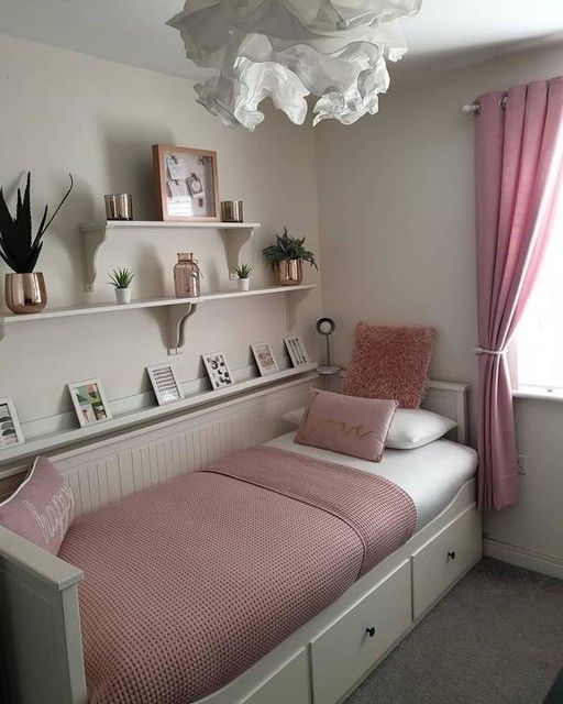 a bedroom with pink bedding and shelves on the wall, along with bookshelves