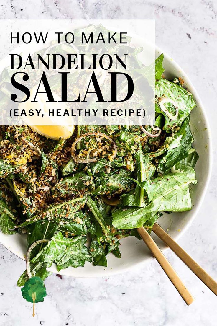 a white bowl filled with green salad and two wooden chopsticks next to it