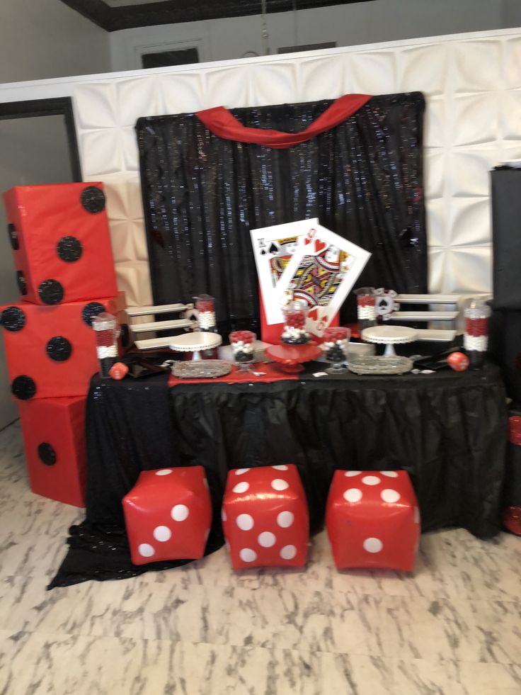 a table topped with red dices next to black and white decor on top of a carpeted floor