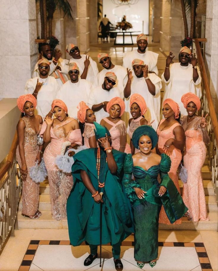 a group of people posing for a photo on the stairs in dresses and turbans