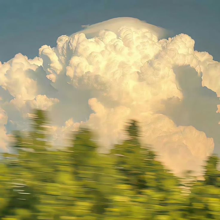 an image of clouds and trees in motion