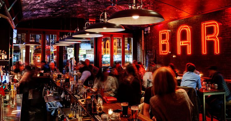 a group of people sitting at tables in a bar