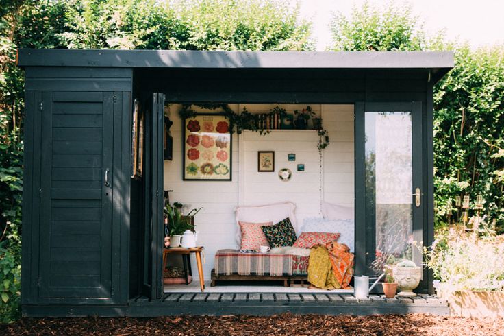 a small green shed with a couch in it