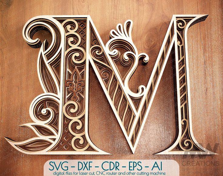 the letter m is made out of wood and has intricate designs on it's sides