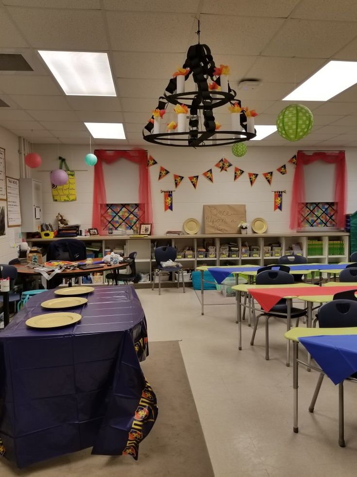 an empty classroom with tables and chairs in front of the desks is decorated with colorful decorations