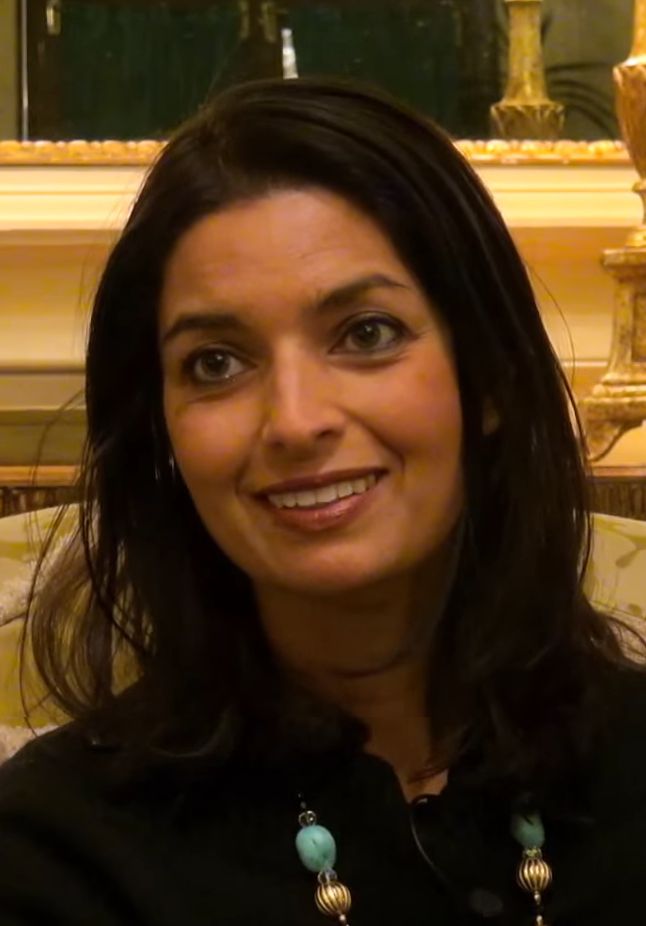 a woman sitting in a chair smiling at the camera