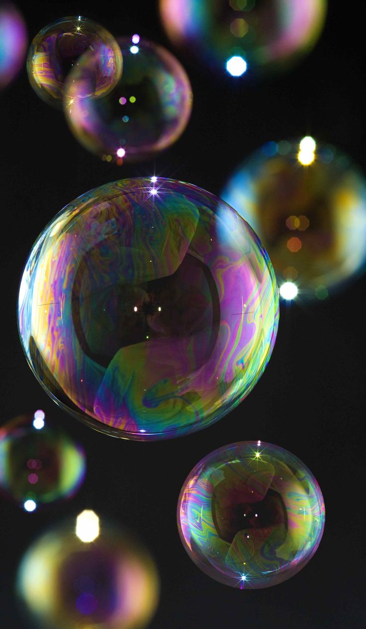 soap bubbles floating in the air on a black background