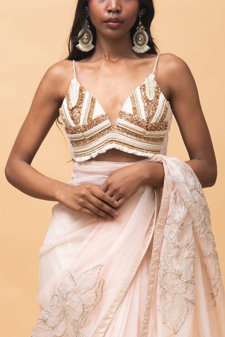 Editor's Note Featuring a rose pink hand embroidered organza sari in addition with kalidar pleats at the bottom teamed up with abstract patterned bralette Color: Rose pink Fabric: Organza Occasion: Festive Components: Sari and bralette Disclaimer: Product color may slightly vary due to photographic lighting sources or your monitor setting. Care: Dry Clean Only About the Designer Rishi & Vibhuti label combines traditional elements with modern aesthetic uniquely to create chic occasion wear for wo Fitted Pink Pre-draped Saree For Summer, Fitted Sleeveless Blouse With Sheer Dupatta, Elegant Fitted Pre-draped Saree For Summer, Summer Georgette Pre-draped Saree For Reception, Summer Reception Saree With Dupatta, Summer Saree With Zari Work For Reception, Summer Reception Saree With Zari Work, Elegant Summer Pre-draped Saree With Dupatta, Sleeveless Summer Festive Pre-draped Saree