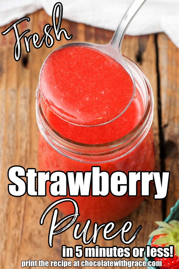 a jar filled with strawberry puree on top of a wooden table