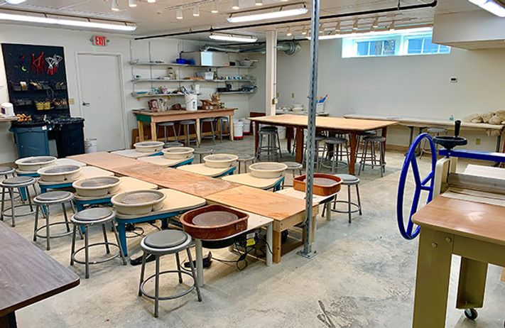 an empty classroom with tables and stools in it's center, surrounded by other desks