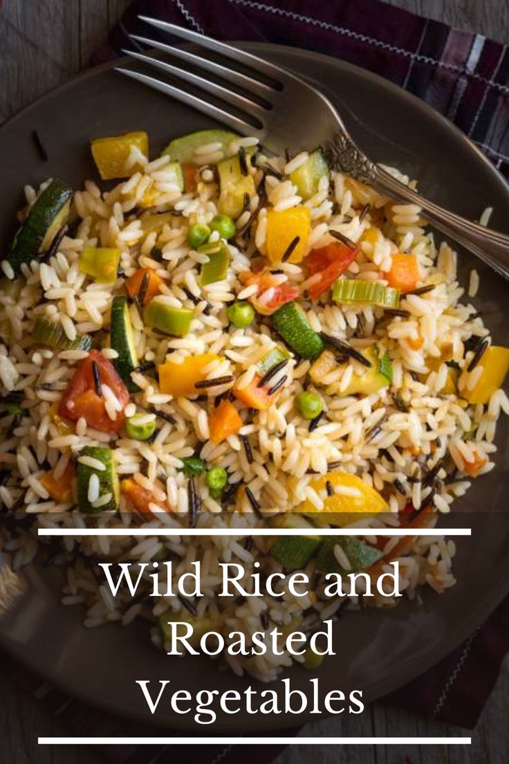 wild rice and roasted vegetables on a black plate with a fork next to it, text overlay reads wild rice and roasted vegetables