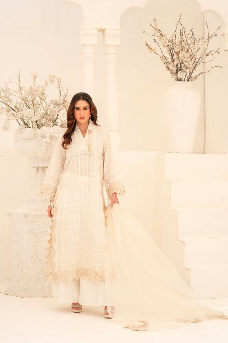 Expertly crafted from khaadi organza, this White Wide Leg Shalwar Kameez features delicate cutwork lace all over the body and the chaak of the shirt. Paired with an organza dupatta featuring cutwork flowers, and khaadi silk palazzo pants for a sophisticated and stylish look. Eid Chanderi Anarkali Set With Lace Work, Elegant Lace Salwar Kameez With Chikankari Embroidery, Elegant Unstitched Salwar Kameez With Lace Work, Elegant Unstitched Lace Work Salwar Kameez, Unstitched Chanderi Anarkali Set With Lace Work, Unstitched Chanderi Sharara With Lace Work, Cambric Anarkali Set With Chikankari Embroidery For Wedding, Wedding Salwar Kameez In Georgette With Naqshi, Bollywood Designer Lawn Suit With Lace Work