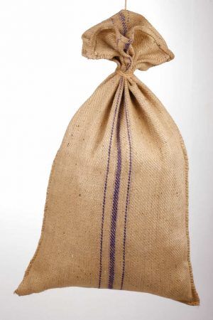 a burlock bag hanging from a string on a white wall with purple stripes