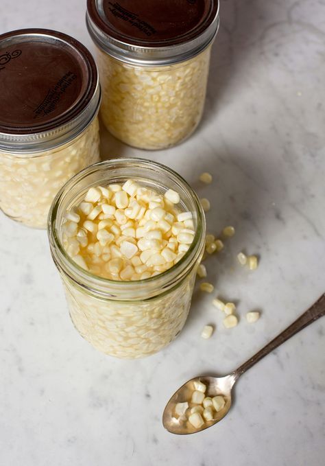 three jars filled with food sitting on top of a white counter next to spoons