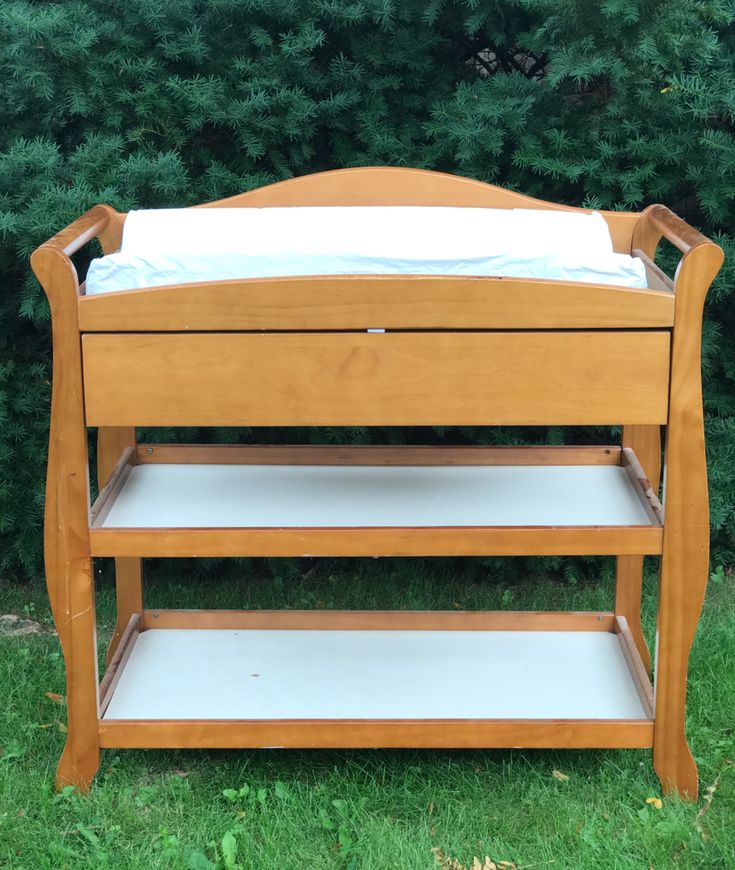 a wooden baby changing table in the grass