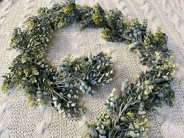 a bunch of green plants laying on top of a white cloth covered table next to scissors