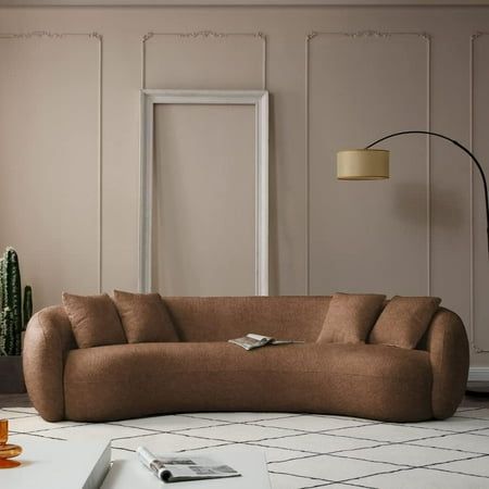 a living room with a couch, table and potted plant on the floor in front of it