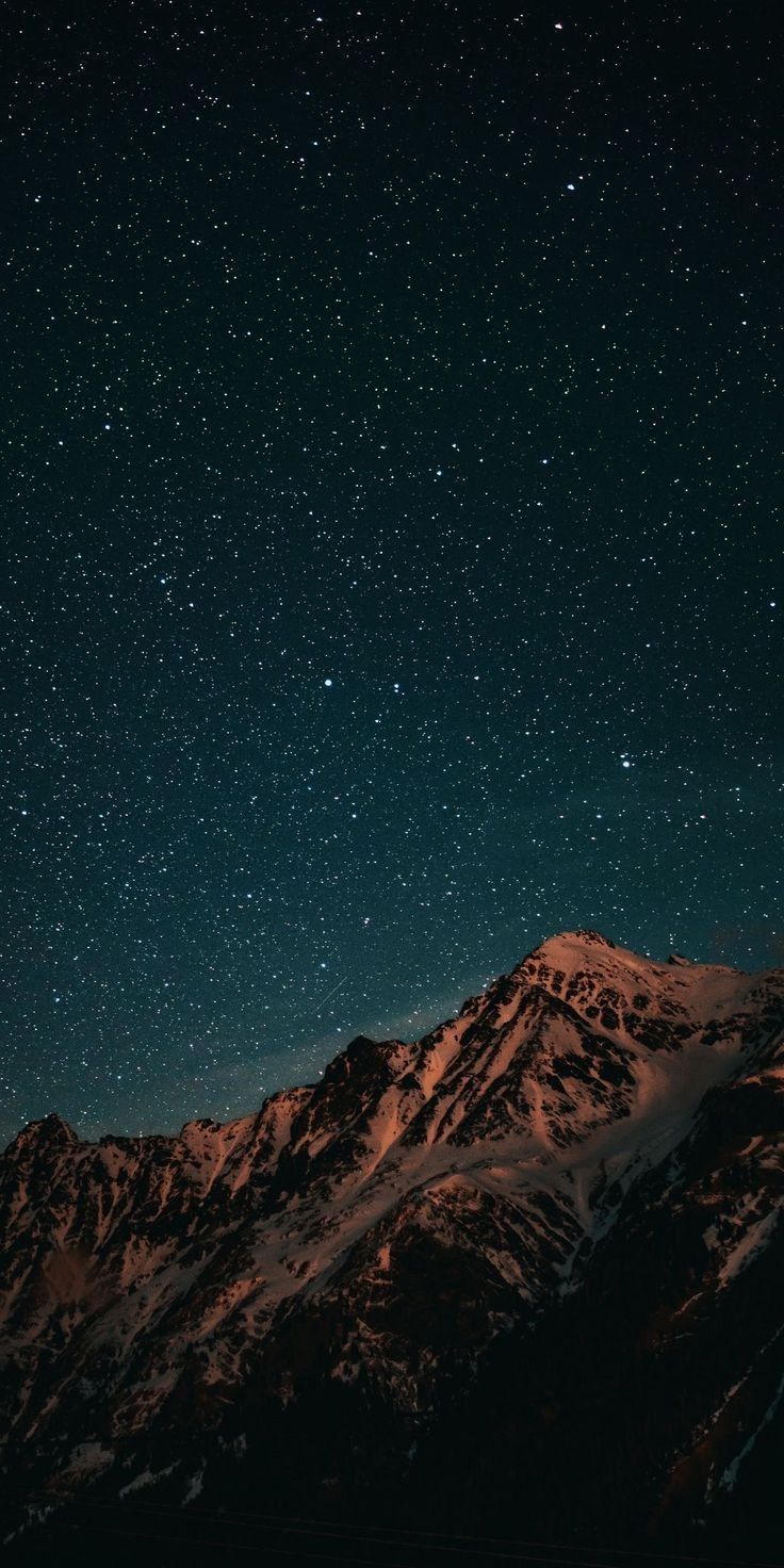 the night sky is filled with stars above mountains