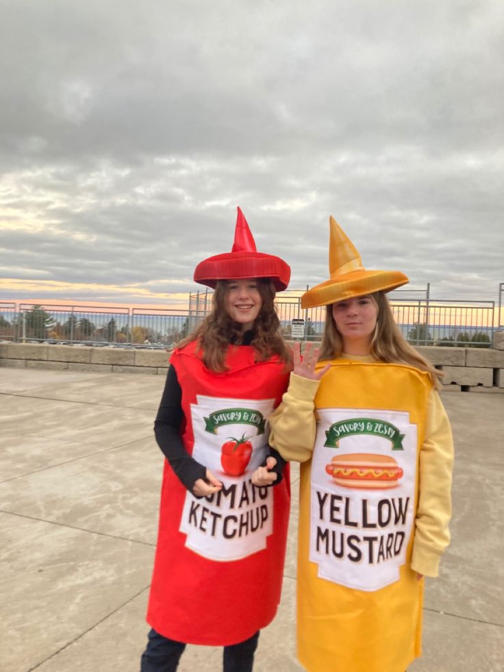 two women dressed in costumes standing next to each other with ketchup and mustard on their shirts