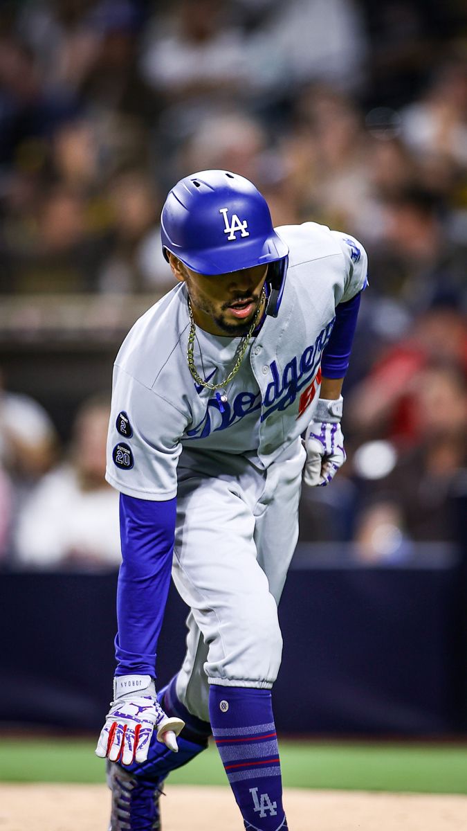 a baseball player in blue and white is on the field with his foot off the ground