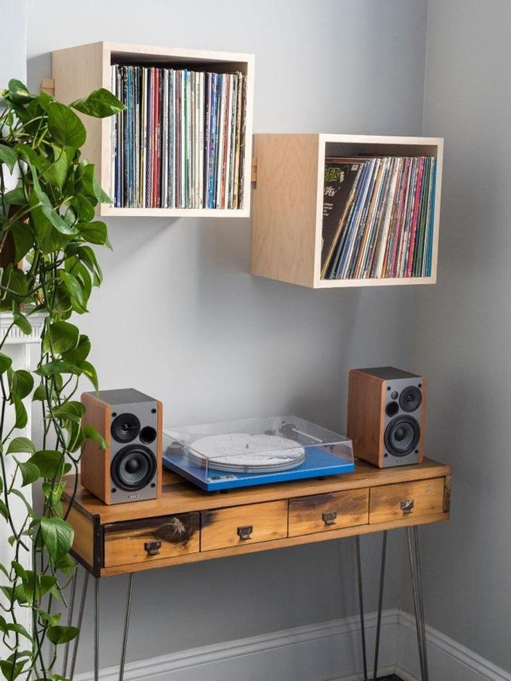 a wooden table with two bookshelves on top of it next to a plant