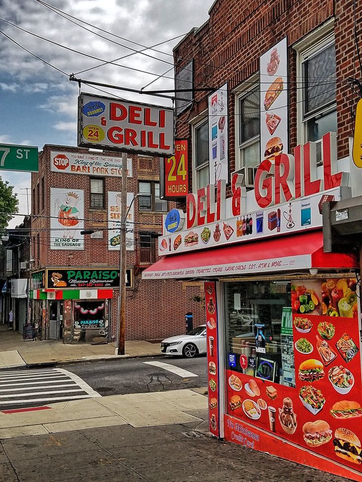 a restaurant called deli and grill on the corner of a street in front of a brick building