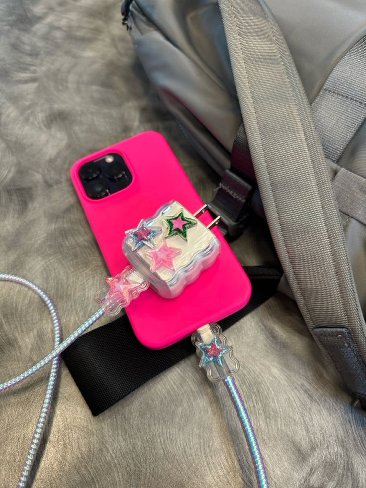 a pink phone case sitting on top of a backpack